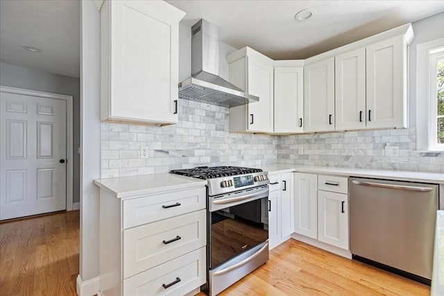 0 Thompson St, Middleboro, MA 02346 - kitchen featuring appliances with stainless steel finishes, wall chimney exhaust hood, light countertops, light wood-style floors, and backsplash