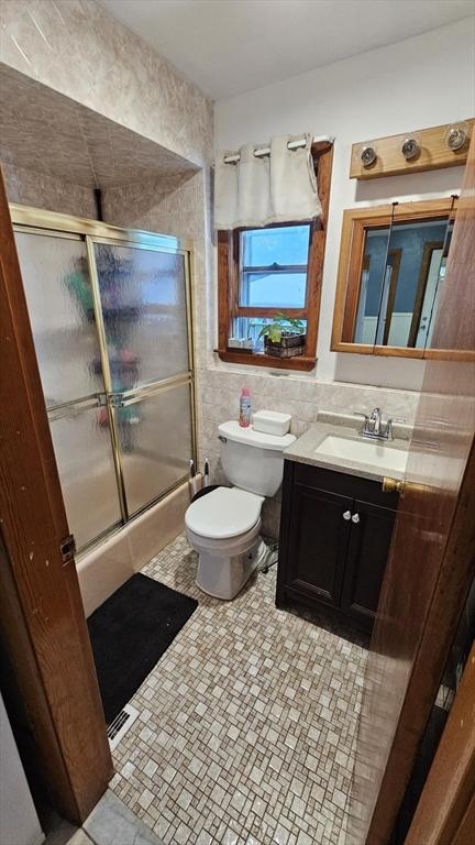 35 Neponset St, Revere, MA 02151 - bathroom with a shower with door, vanity, tile walls, and toilet