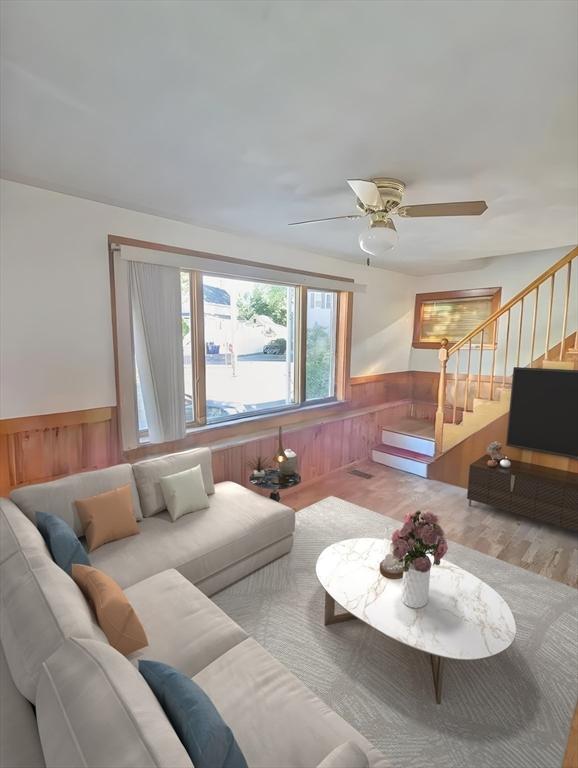 35 Neponset St, Revere, MA 02151 - living room with ceiling fan, wooden walls, wainscoting, wood finished floors, and stairs