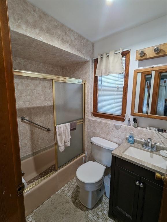 35 Neponset St, Revere, MA 02151 - bathroom with toilet, tile walls, enclosed tub / shower combo, vanity, and tile patterned floors