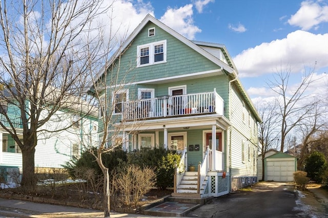 view of front of house with a balcony, a garage, an outdoor structure, and covered porch