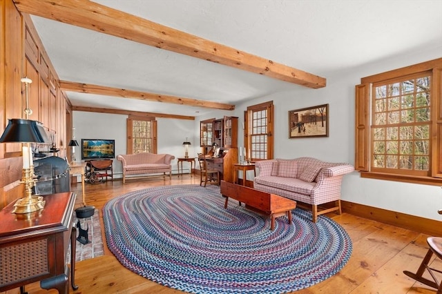 sitting room with beamed ceiling, light wood-style floors, and baseboards