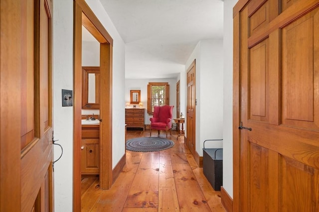 hallway featuring a sink and light wood-style flooring