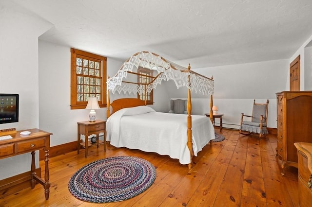 bedroom featuring hardwood / wood-style flooring and baseboards