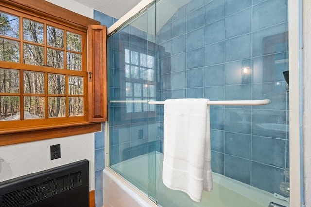 bathroom featuring combined bath / shower with glass door