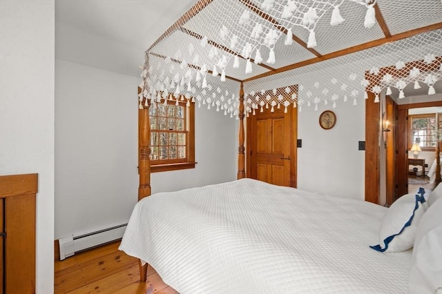 bedroom with wood-type flooring and baseboard heating