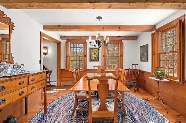 dining room with a baseboard heating unit, beam ceiling, light wood-type flooring, a chandelier, and baseboard heating