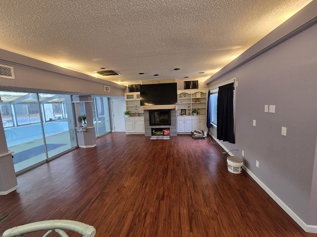 unfurnished living room featuring dark hardwood / wood-style flooring and a textured ceiling