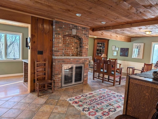 living area with light tile patterned floors, wooden ceiling, and a brick fireplace