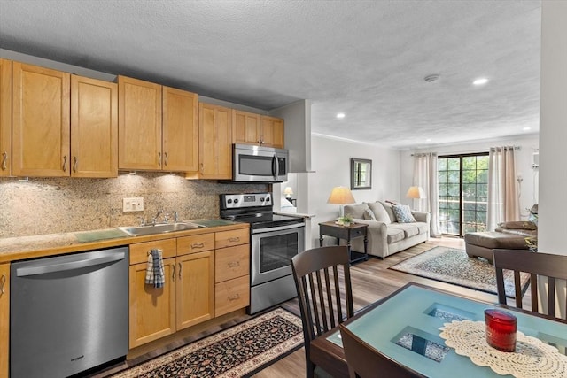 358 Broadway Unit 20, Lynn, MA 01904 - kitchen with appliances with stainless steel finishes, a sink, light wood-style floors, open floor plan, and backsplash