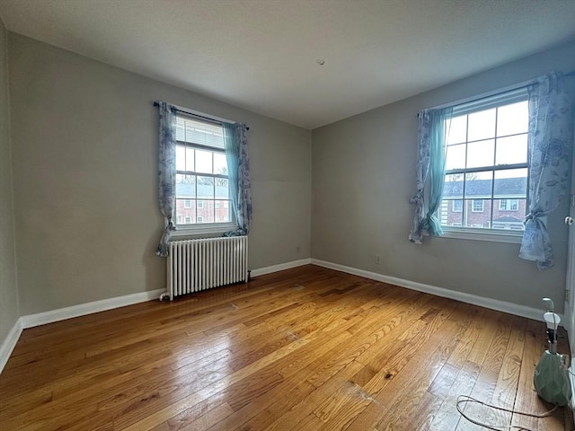 spare room with light hardwood / wood-style flooring and radiator heating unit