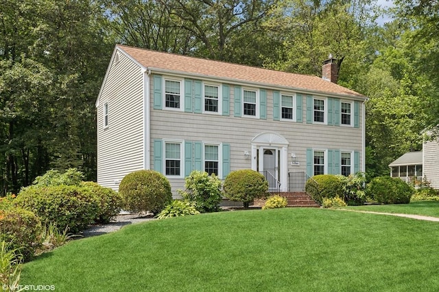 20 Lucia Dr, Milford, MA 01757 - colonial inspired home with a chimney, a front lawn, a shingled roof, and view of scattered trees
