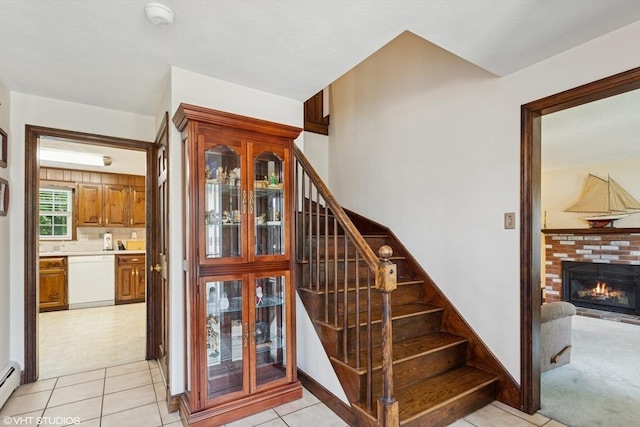 20 Lucia Dr, Milford, MA 01757 - stairs with baseboard heating, tile patterned floors, and a fireplace