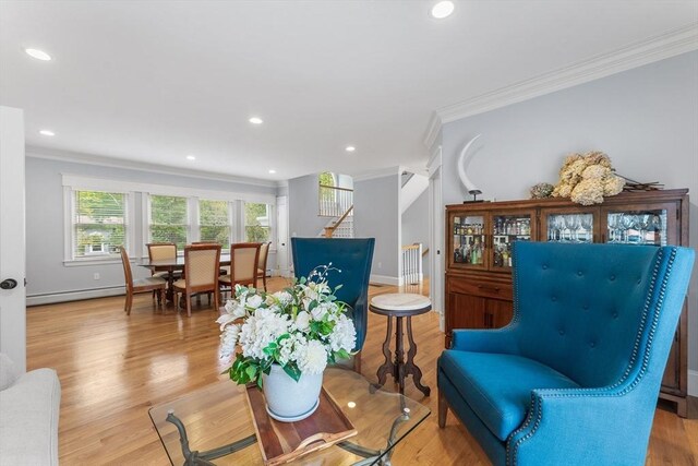 sitting room with stairs, wood finished floors, recessed lighting, and crown molding