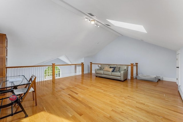 bonus room with visible vents, baseboards, vaulted ceiling with skylight, and light wood-type flooring