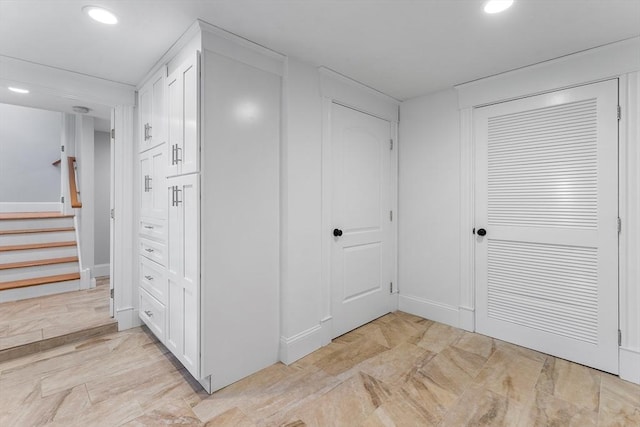 hallway with stairs, baseboards, and recessed lighting