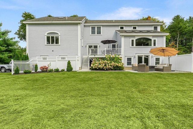 back of house featuring a patio area, a wooden deck, fence, an outdoor hangout area, and a yard