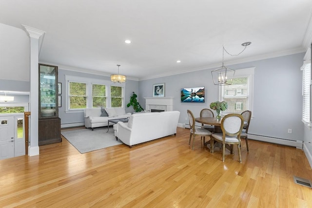 dining space featuring light wood finished floors, visible vents, a chandelier, and a baseboard radiator