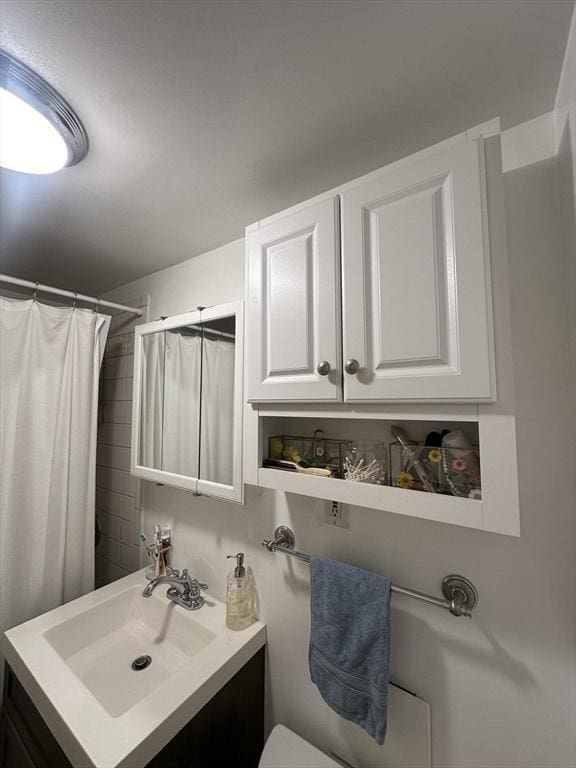 bathroom featuring a shower with shower curtain, vanity, and toilet