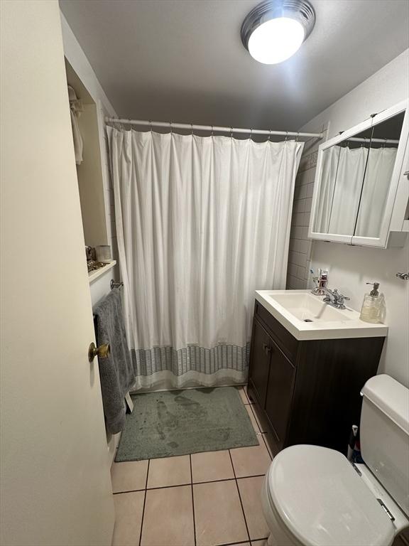 bathroom with tile patterned flooring, vanity, and toilet