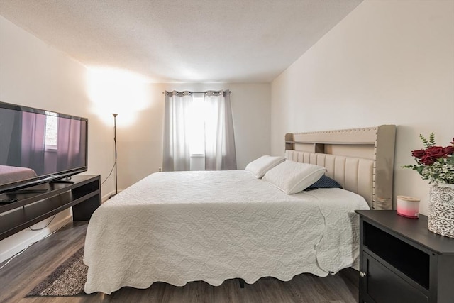 bedroom with dark wood-style flooring