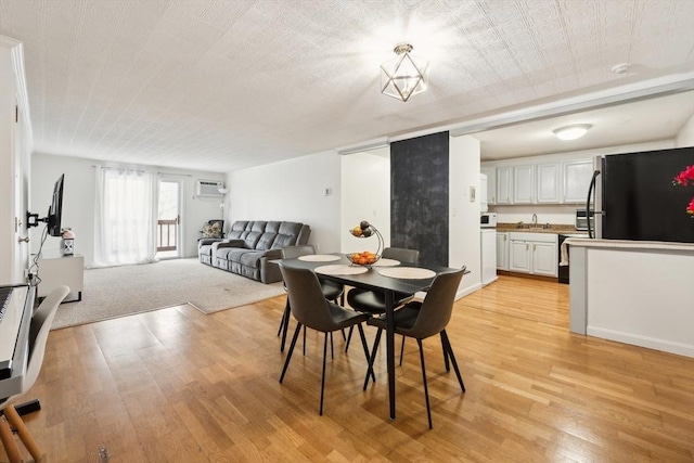 dining space with light wood-type flooring and a wall unit AC