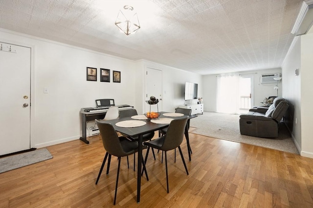 dining room with a wall mounted AC, wood finished floors, and baseboards