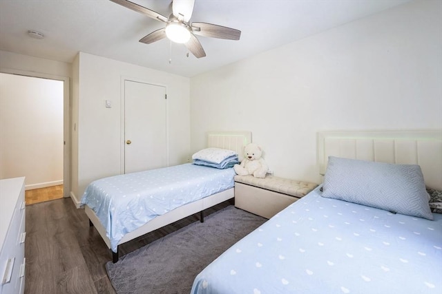 bedroom with baseboards, a ceiling fan, and dark wood-type flooring