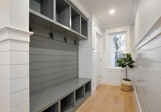 mudroom with ornamental molding and light hardwood / wood-style floors