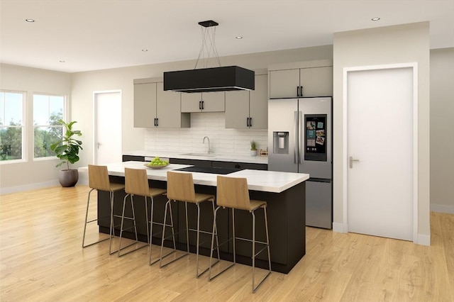 kitchen featuring backsplash, a breakfast bar, light countertops, and stainless steel fridge with ice dispenser