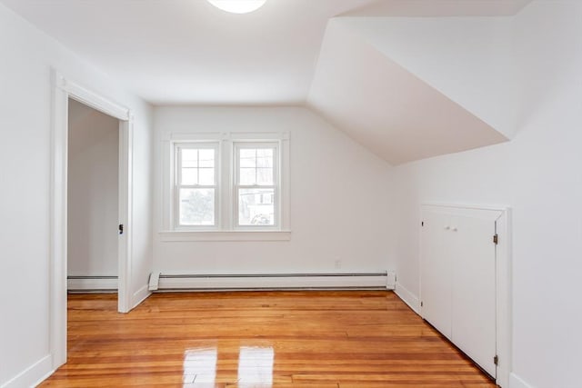 bonus room with light hardwood / wood-style flooring, vaulted ceiling, and baseboard heating