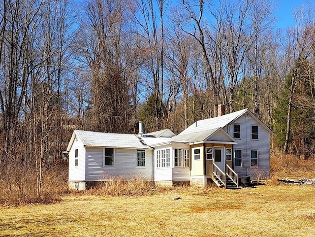 view of front of property with entry steps and a front lawn