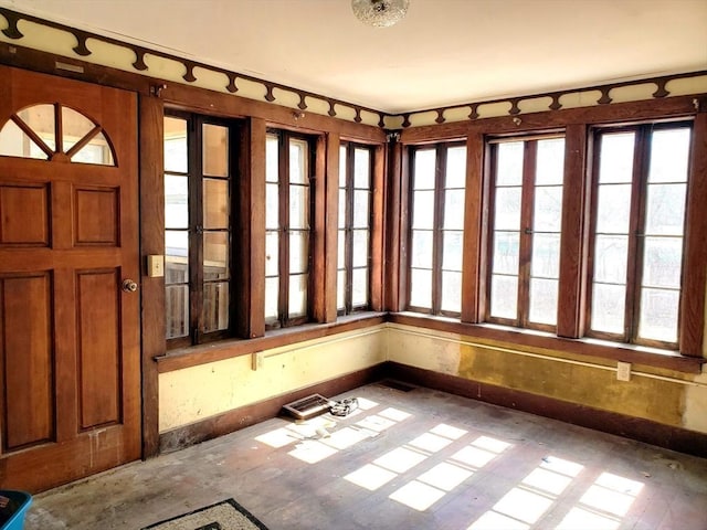 unfurnished sunroom featuring a healthy amount of sunlight and visible vents