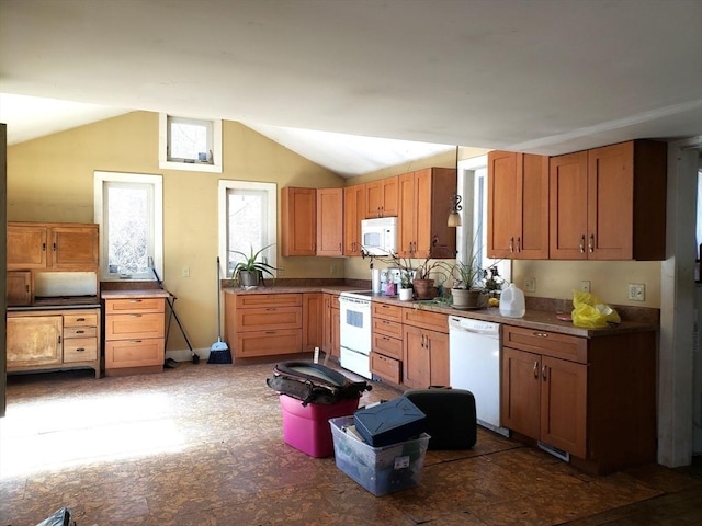 kitchen featuring baseboards, white appliances, brown cabinets, and vaulted ceiling