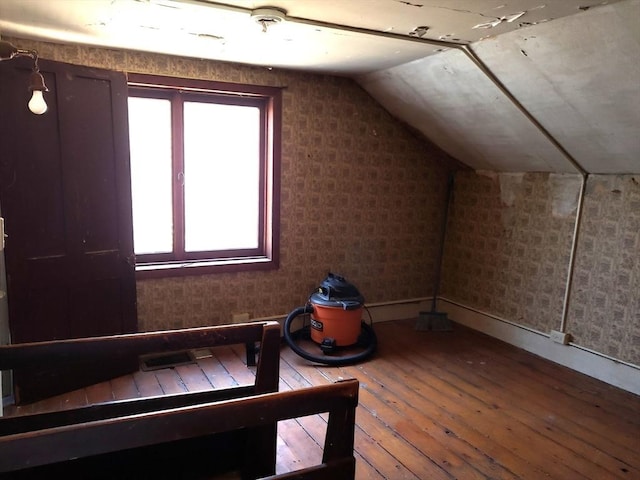 bonus room with lofted ceiling and hardwood / wood-style floors