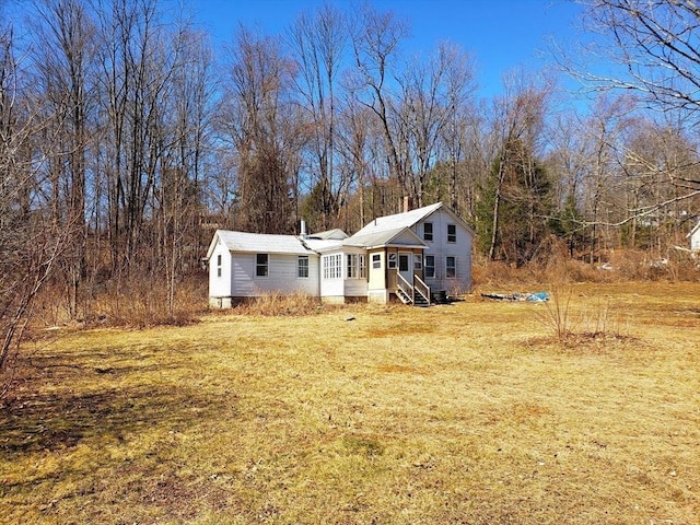 view of front of house featuring entry steps and a front lawn