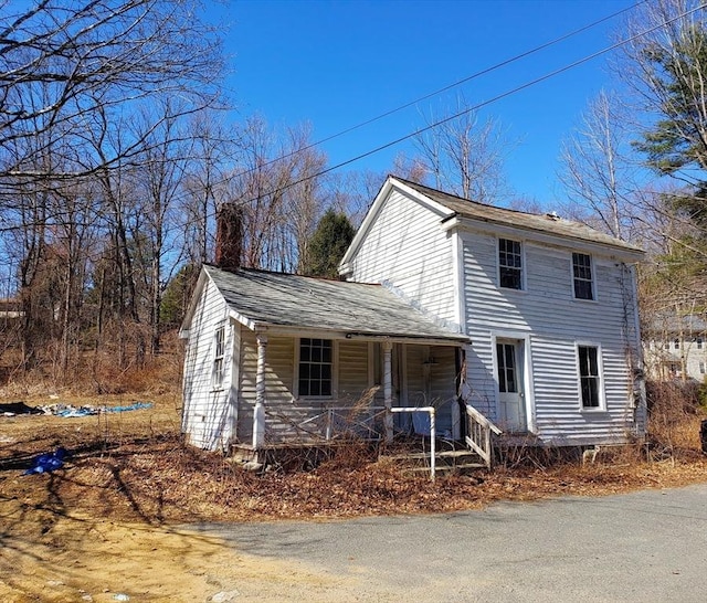 view of front of home with covered porch and a chimney