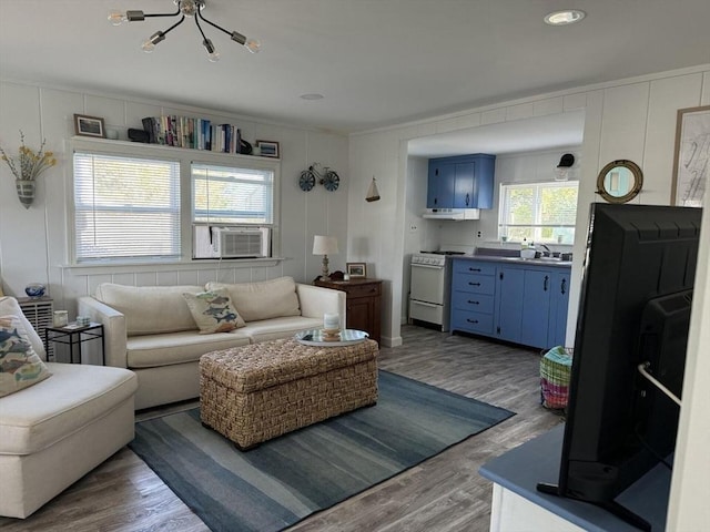 living area featuring crown molding, cooling unit, and wood finished floors