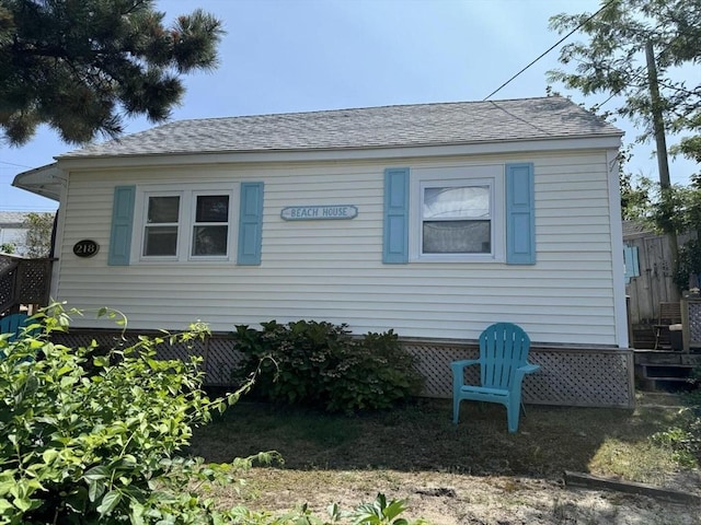 view of front facade featuring fence and a shingled roof