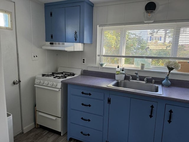 kitchen featuring under cabinet range hood, white range with gas cooktop, blue cabinets, and a sink