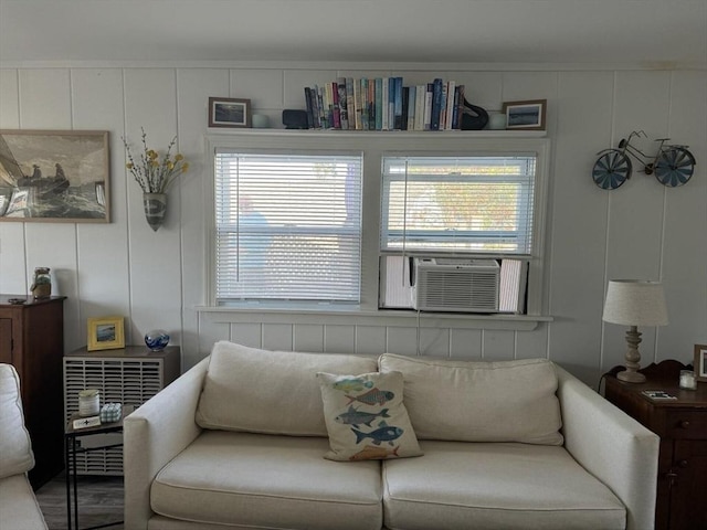 living room with cooling unit and a decorative wall