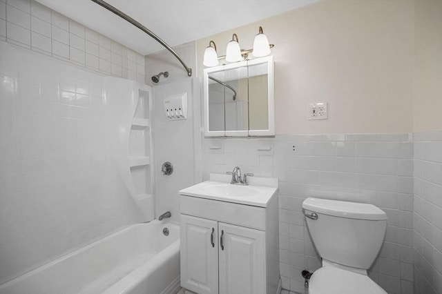 bathroom with toilet, shower / bathtub combination, tile walls, wainscoting, and vanity