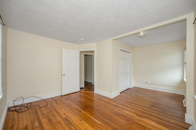 spare room with wood finished floors and baseboards