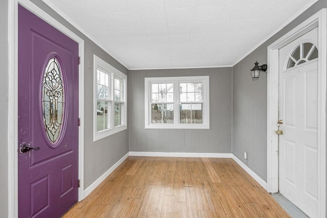 entrance foyer featuring baseboards, light wood-style floors, and crown molding