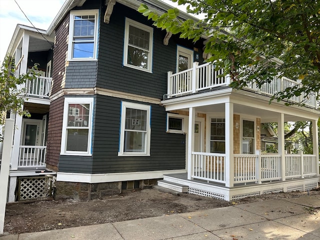 exterior space with covered porch and a balcony