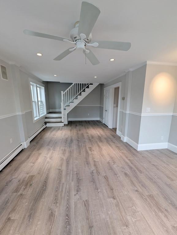 16 Horton St Unit 2, Salem, MA 01970 - unfurnished living room featuring ornamental molding, ceiling fan, stairway, wood finished floors, and baseboards