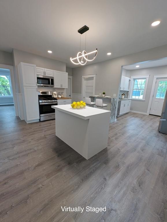 16 Horton St Unit 2, Salem, MA 01970 - kitchen featuring appliances with stainless steel finishes, white cabinets, light countertops, recessed lighting, and wood finished floors