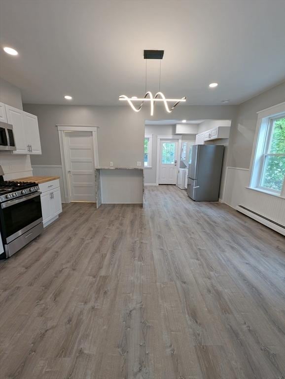 16 Horton St Unit 2, Salem, MA 01970 - kitchen with stainless steel appliances, light wood finished floors, white cabinetry, recessed lighting, and open floor plan