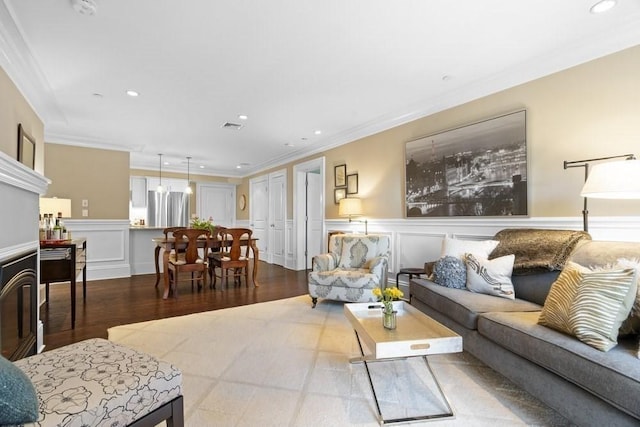 living room featuring recessed lighting, ornamental molding, a decorative wall, and visible vents