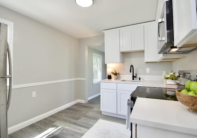 100 Haskin St, Springfield, MA 01109 - kitchen featuring stainless steel appliances, light wood-style flooring, white cabinetry, and light countertops